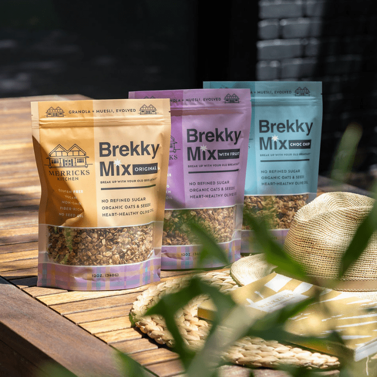 Brekky Mix Variety Pack sitting on outside table with hat and book in forground